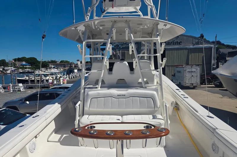 Slide: The Image of 2016 Regulator 41 boat interior with seating and fishing rod holders at a marina. - 23
