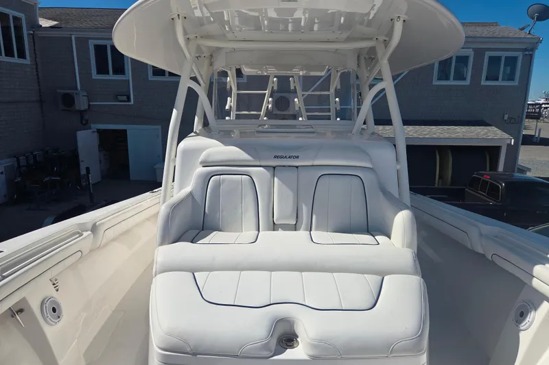 Slide: The Image of 2016 Regulator 41 boat with white seating and T-top, docked near buildings. - 25