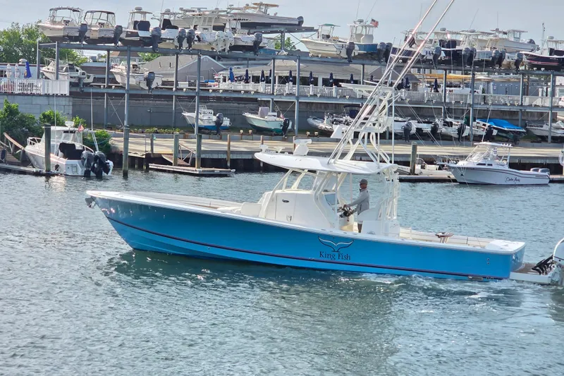 Slide: The Image of 2016 Regulator 41 boat named "King Fish" cruising in a marina with docked boats. - 3