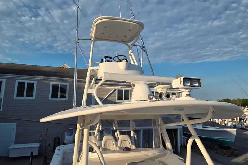 Slide: The Image of 2016 Regulator 41 boat with advanced navigation equipment and tower, docked under a blue sky. - 8