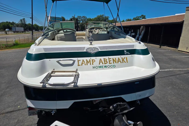 Slide: The Image of 1996 Cobalt 232 boat with "Camp Abenaki Homewood" text, parked on pavement. - 3