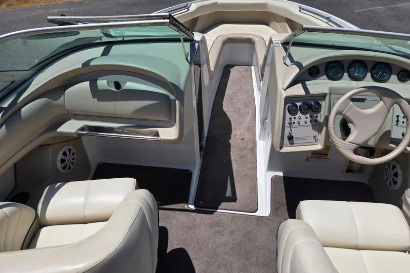 Slide: The Image of Interior of a 1996 Cobalt 232 boat with beige seating and dashboard controls. - 4