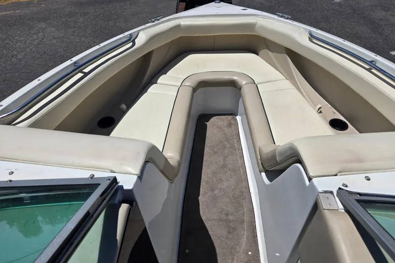 Slide: The Image of Interior view of a 1996 Cobalt 232 boat, featuring beige seating and carpeted flooring. - 7