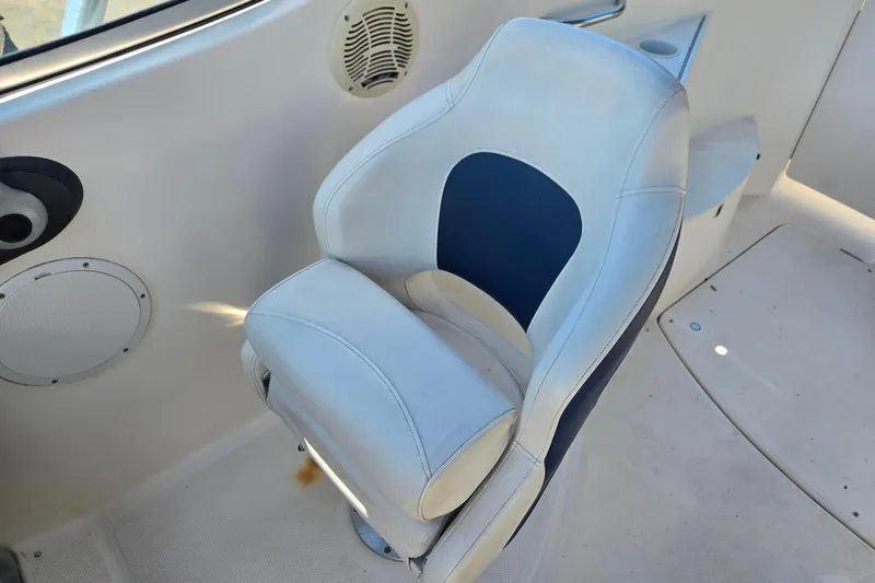 Slide: The Image of Captain's chair on a 2006 Bayliner 265 boat, featuring white and blue upholstery. - 12