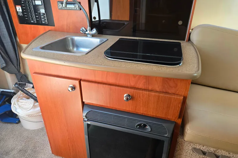 Slide: The Image of Compact kitchen area in a 2006 Bayliner 265 boat with sink and stove. - 15