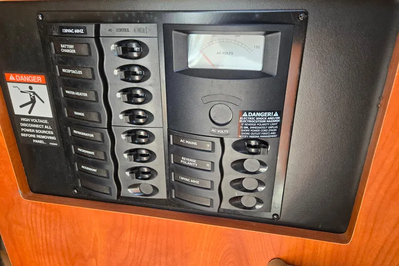Slide: The Image of Electrical control panel on a 2006 Bayliner 265 boat, featuring various switches and voltage meter. - 17
