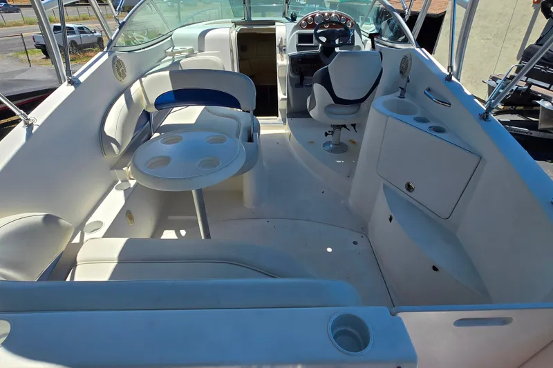 Slide: The Image of 2006 Bayliner 265 boat interior with seating, table, and helm station. - 21