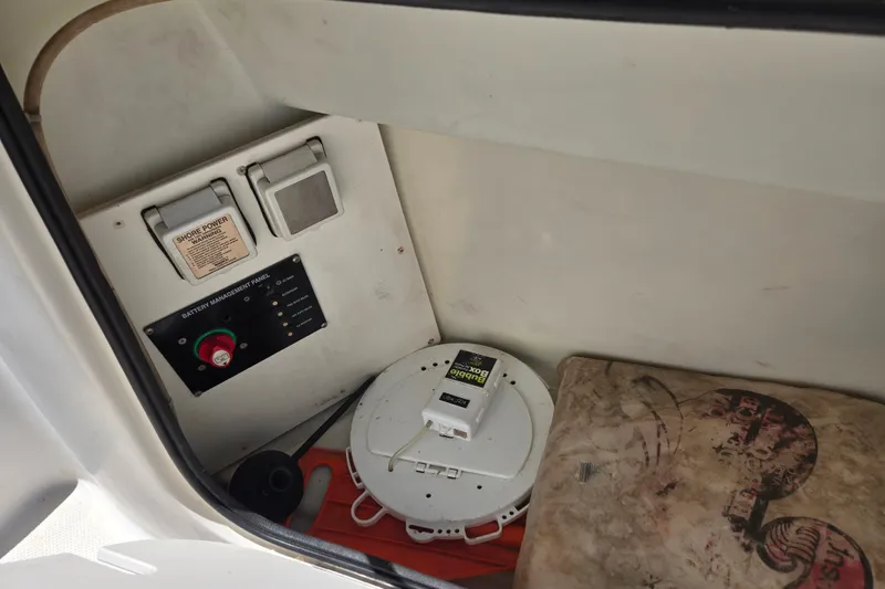Slide: The Image of 2006 Bayliner 265 boat interior showing battery management panel and storage area. - 7