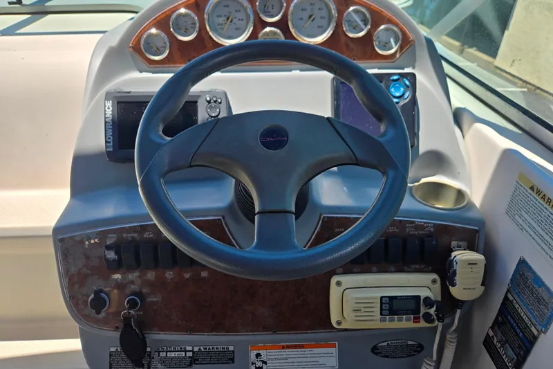 Slide: The Image of Dashboard of a 2006 Bayliner 265 boat with steering wheel and navigation instruments. - 8