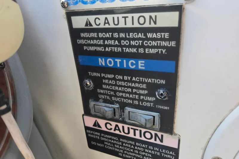 Slide: The Image of Caution notice on 2006 Bayliner 265 boat for legal waste discharge procedures. - 9
