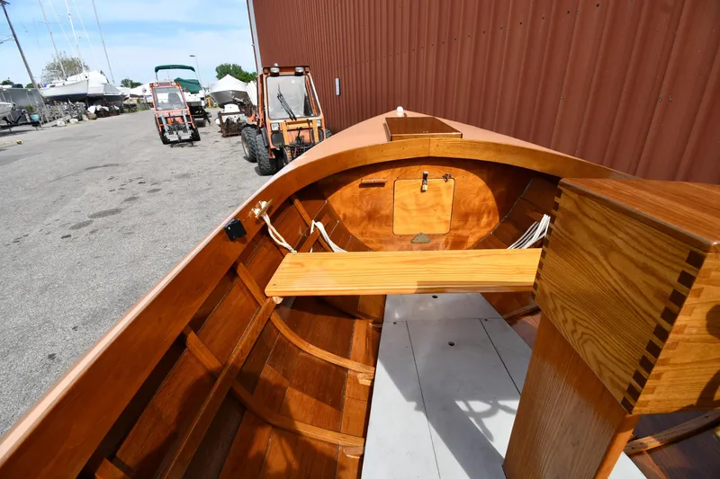 Slide: The Image of 2003 Great Lakes 16 Skiff boat interior with wooden finish, docked near tractors. - 14