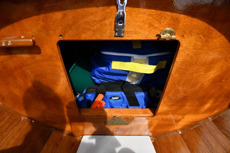 Slide: The Image of Storage compartment on a 2003 Great Lakes 16 Skiff, containing blue bags and gear. - 17