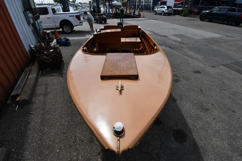 Slide: The Image of 2003 Great Lakes 16 Skiff boat on pavement, showcasing sleek wooden design. - 6