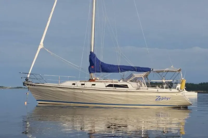 The Image of 1988 O'Day sailboat "Zephyr" with blue sail cover, anchored on calm water. - 0