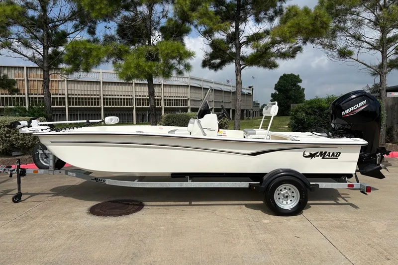 The Image of 2026 Mako Pro Skiff 17 CC boat on trailer, parked outdoors near trees. - 0