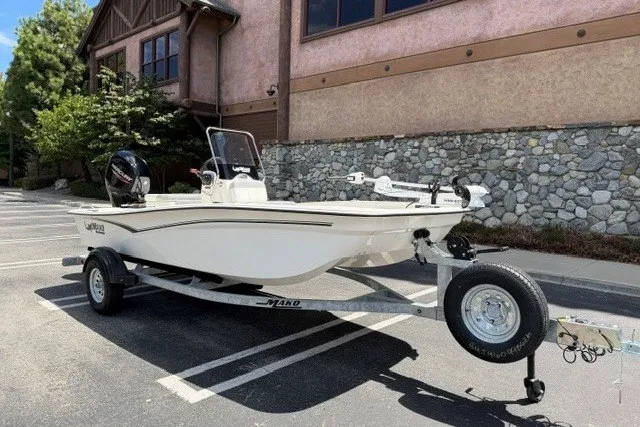 Slide: The Image of 2026 Mako Pro Skiff 15 CC boat on trailer in parking lot. - 2