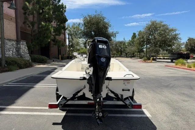 Slide: The Image of 2026 Mako Pro Skiff 15 CC boat with 60 HP engine in parking lot. - 4