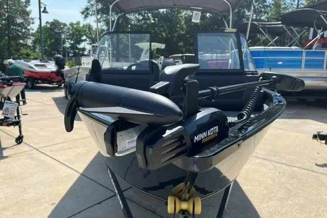 Slide: The Image of 2026 Tracker Pro Guide V-16 WT boat with Minn Kota trolling motor displayed outdoors. - 2