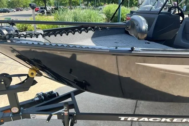 Slide: The Image of 2026 Tracker Pro Guide V-16 WT boat on trailer, sleek black design, outdoor setting. - 8