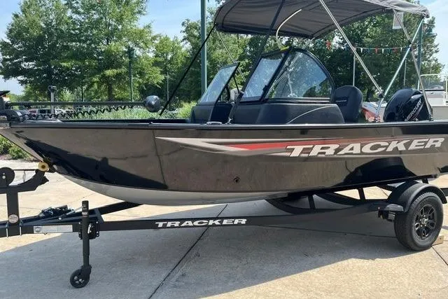 The Image of 2026 Tracker Pro Guide V-16 WT boat on trailer, parked outdoors. - 0