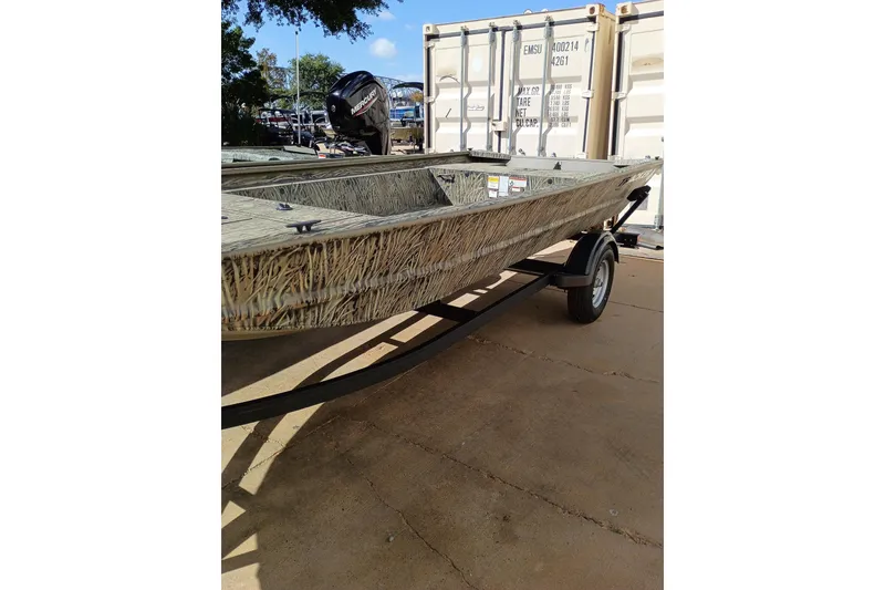 The Image of 2026 Tracker Grizzly 1754 Utility boat on trailer, outdoors, with camouflage design. - 0