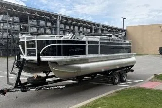 Slide: The Image of 2026 Sun Tracker SportFish 20 DLX pontoon boat on trailer in parking lot. - 2