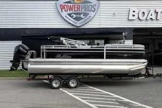 The Image of 2026 Sun Tracker SportFish 20 DLX pontoon boat on trailer outside dealership. - 0