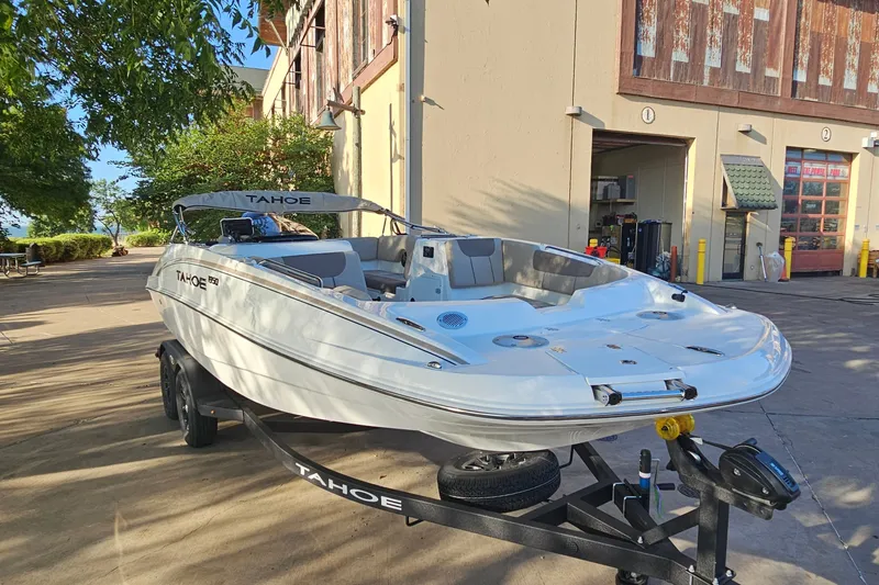 Slide: The Image of 2026 Tahoe 1950 boat on trailer outside a building, surrounded by trees. - 3