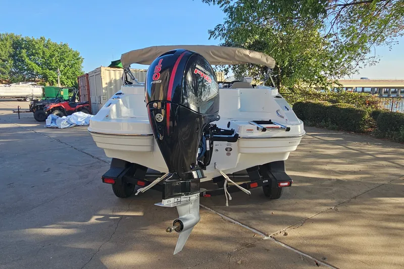 Slide: The Image of 2026 Tahoe 1950 boat with Mercury 150 outboard motor, parked outdoors. - 6