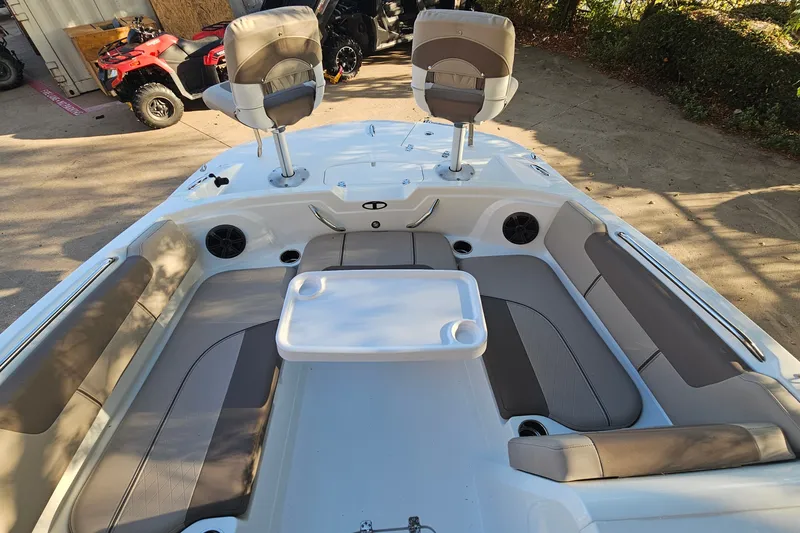 Slide: The Image of 2026 Tahoe 1950 boat interior with seating and table, parked near ATVs. - 11