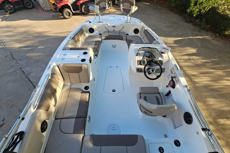 Slide: The Image of 2026 Tahoe 1950 boat interior with seating and steering wheel, parked on concrete. - 8