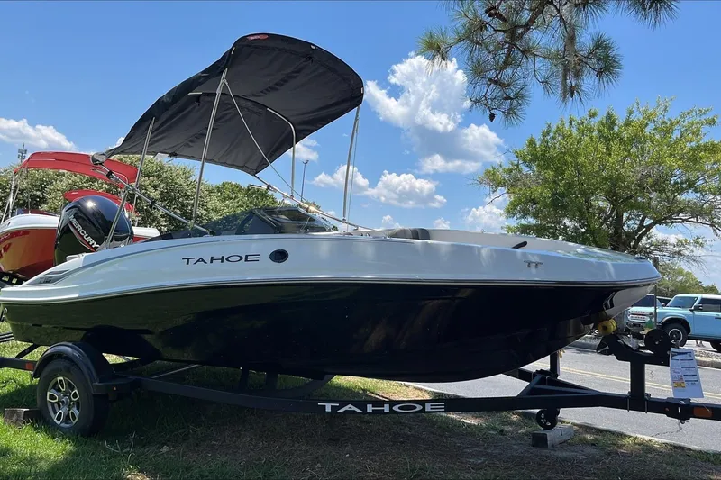 The Image of 2026 Tahoe T16 boat with canopy on trailer, parked outdoors under blue sky. - 0