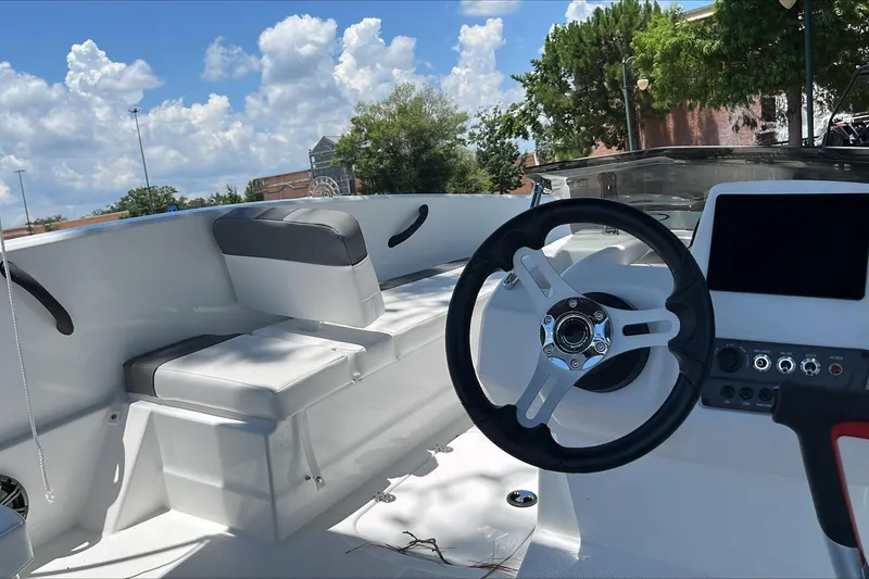 Slide: The Image of Interior of 2026 Tahoe T16 boat with steering wheel and seating under blue sky. - 6