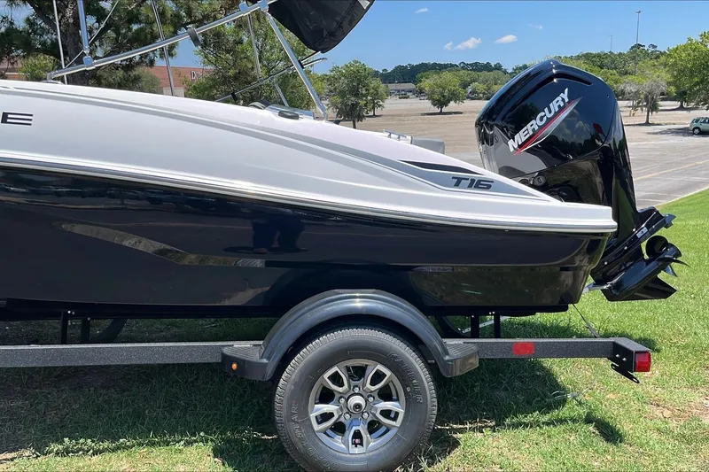 Slide: The Image of 2026 Tahoe T16 boat with Mercury engine on a trailer, parked on grass. - 3