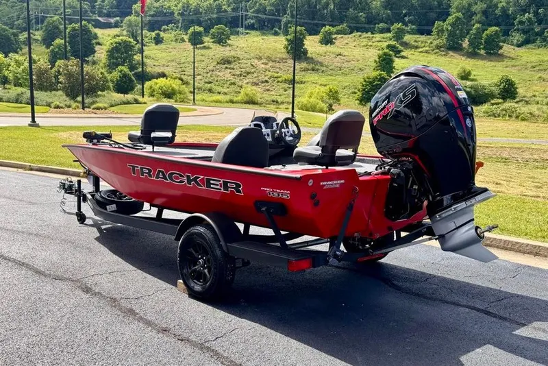 Slide: The Image of Red 2026 Tracker Pro Team 195 boat on trailer, parked on asphalt with scenic background. - 4