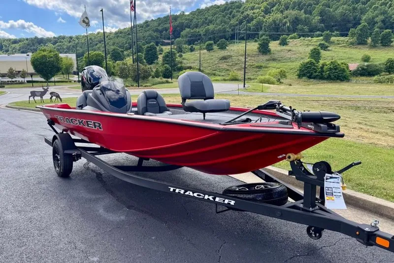 Slide: The Image of Red 2026 Tracker Pro Team 195 boat on trailer, parked outdoors with scenic background. - 2