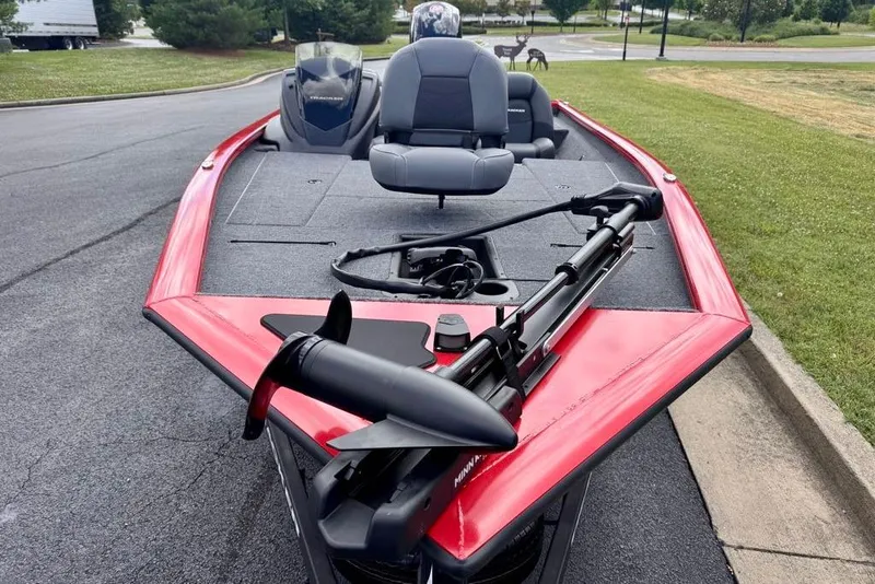 Slide: The Image of 2026 Tracker Pro Team 195 boat with red trim and trolling motor, parked on pavement. - 6
