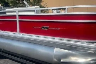 Slide: The Image of 2026 Sun Tracker Fishin' Barge 22 DLX pontoon boat with red exterior detailing. - 2