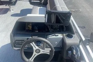 Slide: The Image of 2026 Sun Tracker Fishin' Barge 22 DLX dashboard with steering wheel and navigation system. - 3