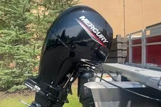 Slide: The Image of 2026 Sun Tracker Fishin' Barge 22 DLX with Mercury outboard motor, parked outdoors. - 4