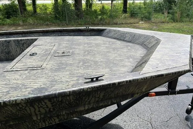 Slide: The Image of 2026 Tracker Grizzly 1754 Utility boat with camouflage design on a trailer. - 4