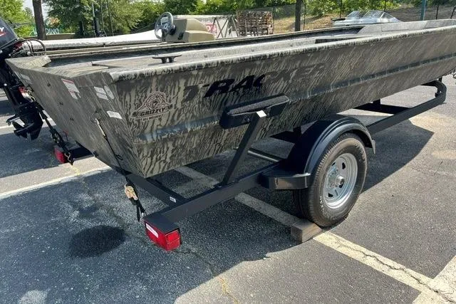 Slide: The Image of 2026 Tracker Grizzly 1754 Utility boat on trailer, parked outdoors in a sunny setting. - 2