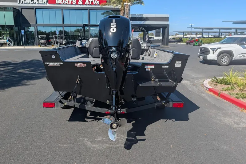 Slide: The Image of 2026 Tracker Pro Guide V-175 Combo boat with 150 HP engine, parked outside dealership. - 2