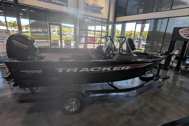 Slide: The Image of 2026 Tracker Pro Guide V-175 Combo boat displayed in showroom with promotional banners. - 8