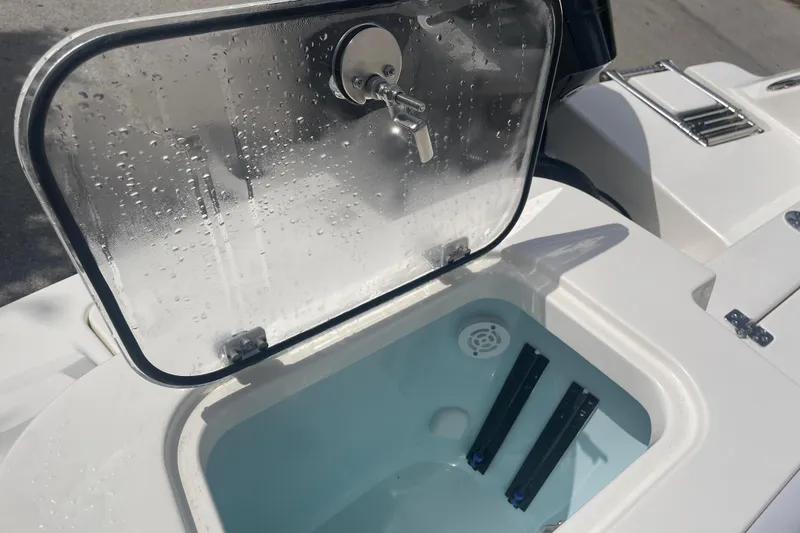 Slide: The Image of Open storage compartment on 2026 Mako 226 Center Console boat, featuring a secure lock. - 10