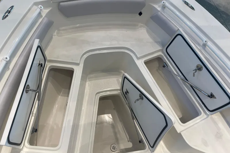 Slide: The Image of 2026 Mako 226 Center Console boat storage compartments with open hatches. - 5