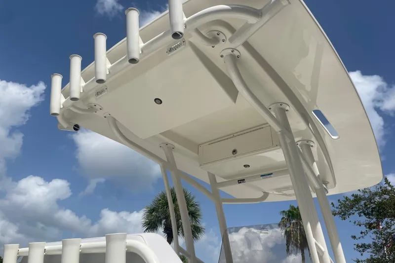 Slide: The Image of 2026 Mako 226 Center Console boat with rod holders and T-top under a blue sky. - 7
