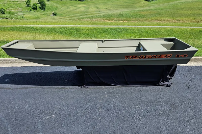 The Image of 2026 Tracker Grizzly 14 Jon boat displayed outdoors on pavement with grassy background. - 0