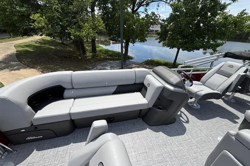 Slide: The Image of 2026 Sun Tracker SportFish 20 DLX pontoon boat with spacious seating by a serene lake. - 10
