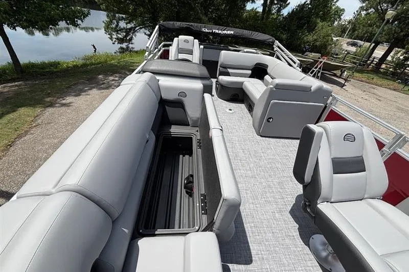 Slide: The Image of 2026 Sun Tracker SportFish 20 DLX pontoon boat with spacious seating and storage, docked by a lake. - 13